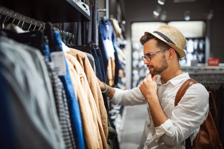 Handsome man shopping for new clothes in store